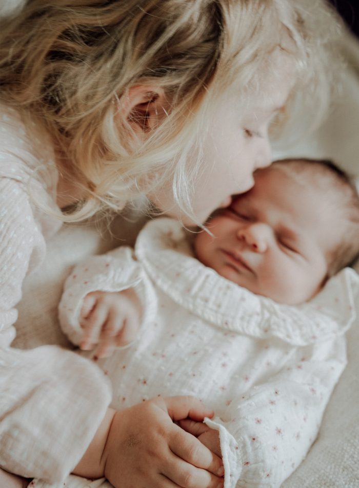 Große Schwester mit Baby beim Neugeborenen Shooting